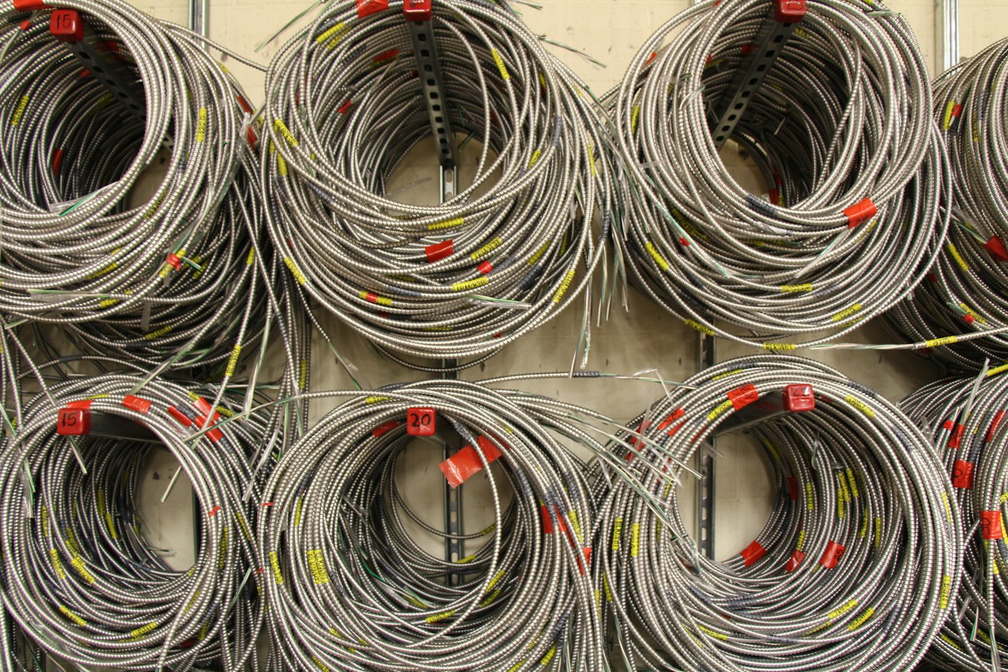 Tubería eléctrica de metal enrollada ordenadamente en estanterías.