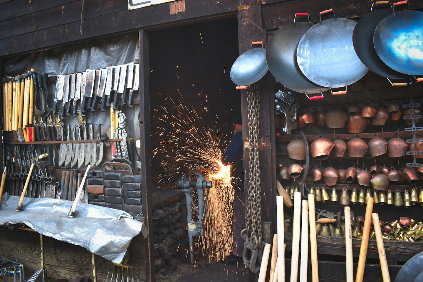 Un artesano usa una amoladora en metal dentro de un taller.